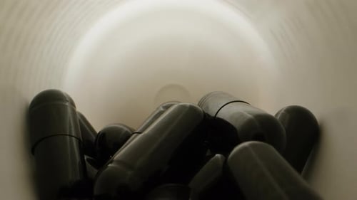 Dark Capsules Inside Medicine Container Close Up