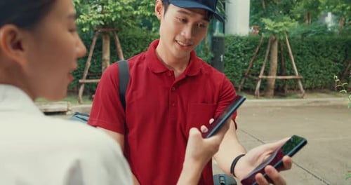 Young happy Asian woman accept paper bag from delivery man with bicycle.