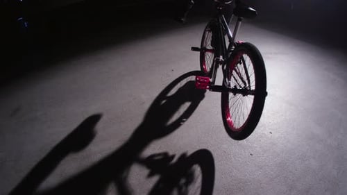 Young bmx rider performing extreme stunts in dark urban warehouse on red epic