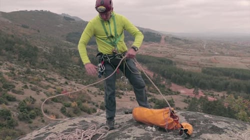 Climber preparing a rope for climbing. Outdoor sport activity.