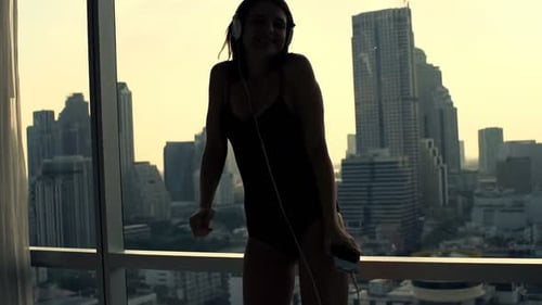 Woman listening to music and dancing in bodysuit