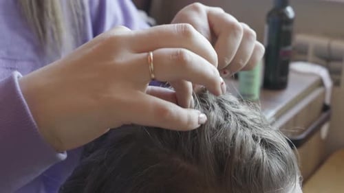 Female Stylist Hands Carefully Examining and Grooming Hair Indoors