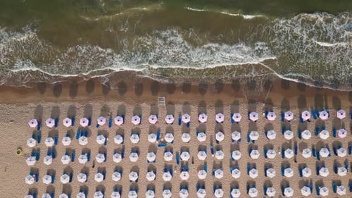 Aerial View of an Amazing Empty Sand Beach with Straw Beach Umbrellas and Turquoise Clear Water