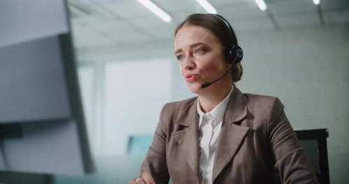 Woman Talking with Headset at Computer Workstation