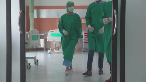 Team surgeon in uniform success surgery and walking go out from operating room at hospital.