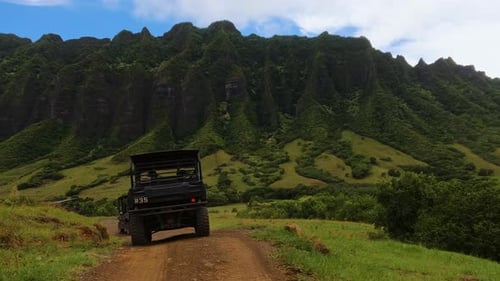 ATV off-road driving through green mountain park. Nature in Hawaii. Driving through dirt