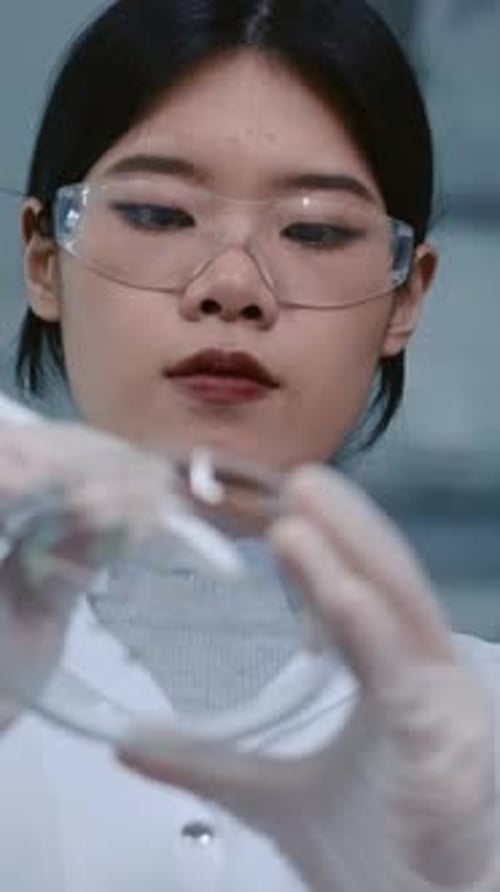 Scientist Examines Plant Sample in Petri Dish