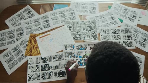 Artist Drawings a Comic at Wooden Table