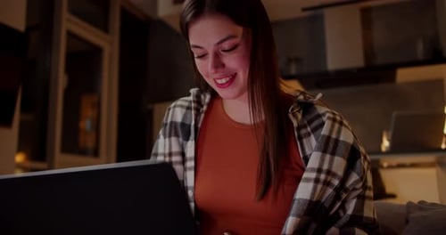 Smiling Young Woman Using Laptop At Home
