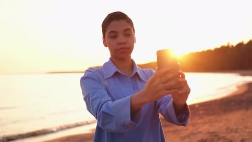 Woman Taking Selfie at Sunset on Beach