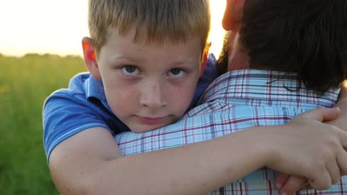 Child Embracing Adult During Sunset in Rural Setting