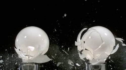 Lightbulbs exploding in slow motion against black backdrop