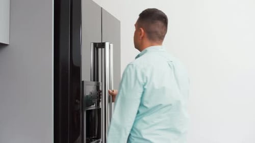 Man Getting Food from the Refrigerator in Kitchen