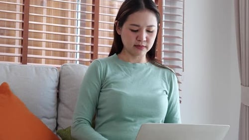 Woman Using Laptop While Sitting on Couch