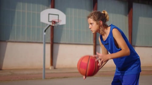 Young Athlete Practicing Basketball on Outdoor Court