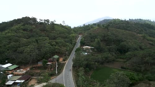 Motorcycles Driving at High Speed on a Narrow Road Between the Mountains and the Jungle of Vietnam