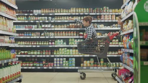 Family Outing with Joyful Moments Mother Pushes Child Through Supermarket Aisles Amid Cheerful