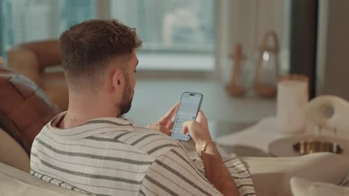 Man Relaxing at Home Using Phone
