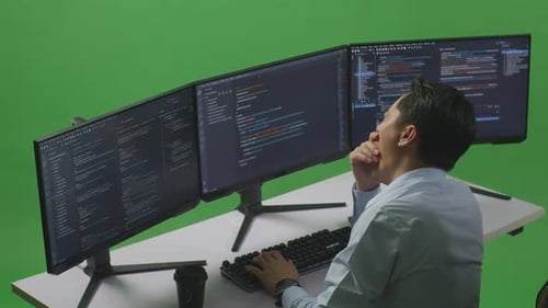 Tired Man Yawning Before Sleeping While Write Code With Multiple Computer Screens In Green Screen
