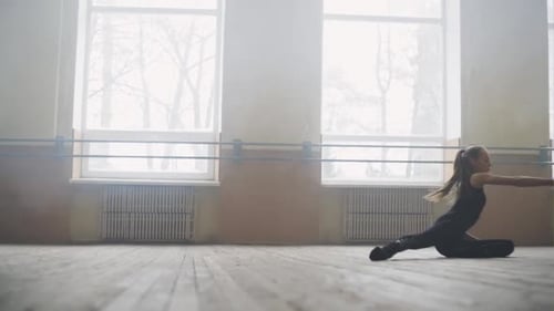Young Girl Ballet Dancer in Black Sportswear Practicing Alone in Large Empty Hall Gracefully Doing