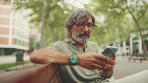 Adult Using Mobile Phone on Park Bench