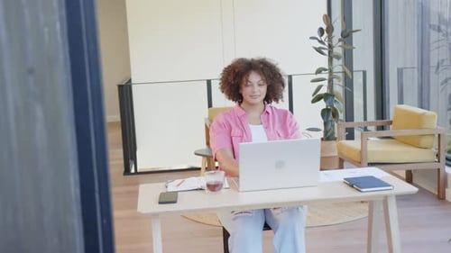 Stretching arms, plus size woman taking break from work at home office desk