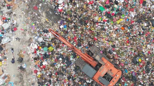 Aerial view of an excavator working in a landfill in bali