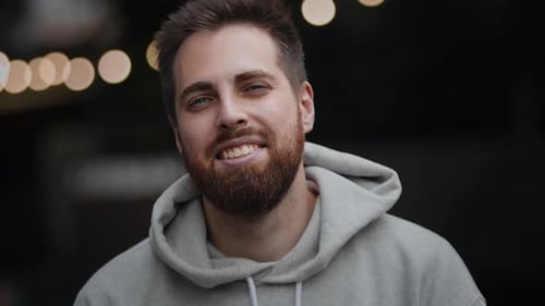 Close-up of a bearded man looking at the camera and smiling, happy