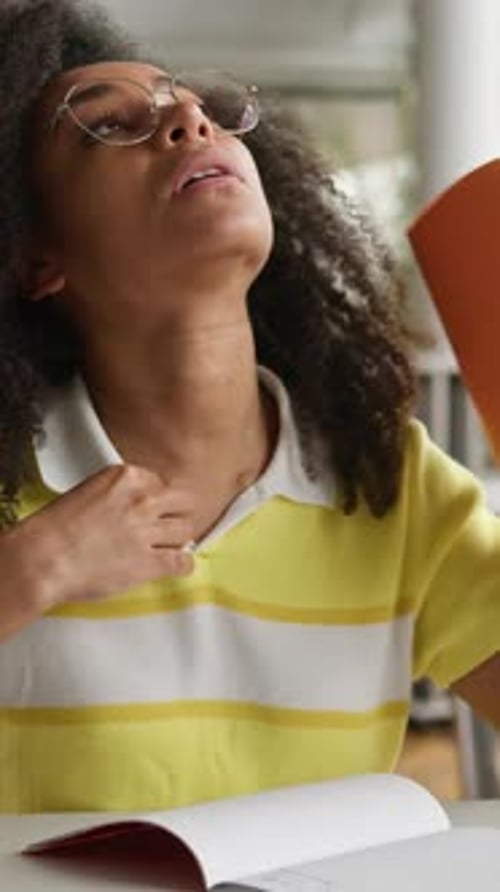 Tired Exhausted Sweaty African American Student Girl Blowing with Copybook Blow Wind Holding