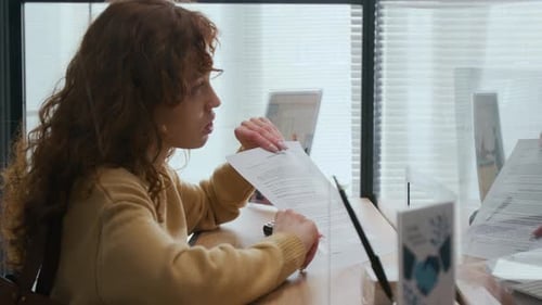 Male Bank Assistant Helping Woman with Paperwork