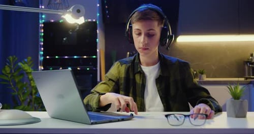 Boy using laptop working on a school project, drawing in a notebook with a pencil, planning