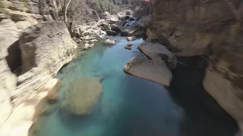 FPV-Drohne taucht in eine Schlucht, um dem Fluss zu folgen
