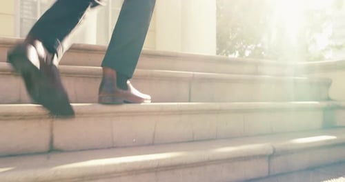 4k video footage of a young businessman walking up the steps in the city
