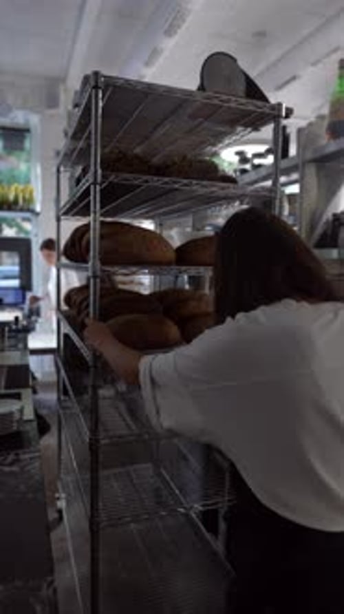 Person Reaching for Bread Loaf in Kitchen