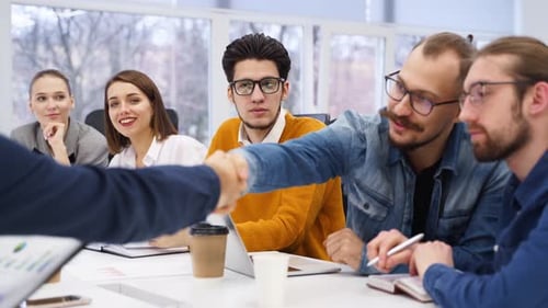 Business People Negotiate and Reach Successful Agreement By Shaking Hands in Office Partners Signing