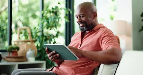 Man Using Tablet on Couch in Bright Home