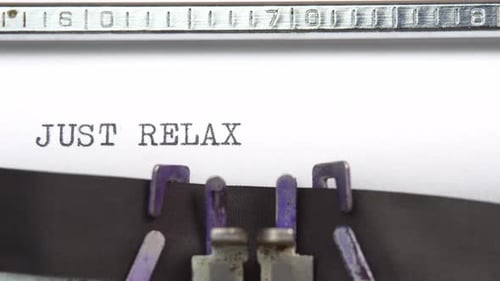 Just relax phrase closeup being typing and centered on a sheet of paper on old vintage typewriter