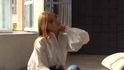 Young Woman Sitting on the Floor in Apartment