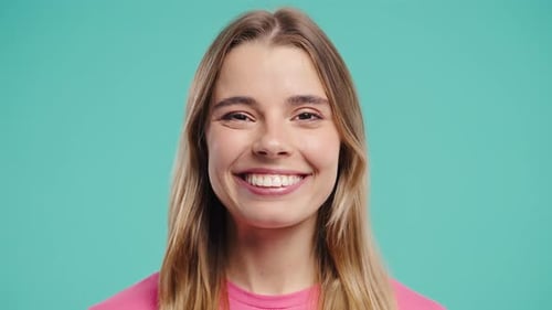 Smiling Woman in Pink Shirt on Blue Background