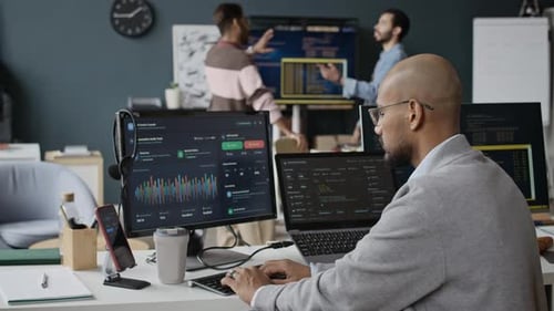 Indian Male Software Developer Coding on Computers in Diverse Tech Office
