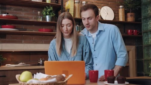 Couple Using Laptop Together in Charming Kitchen