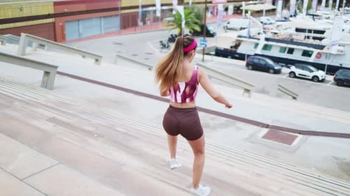 Woman Running Up Steps Outdoors in Daytime