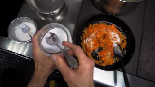 Adding Salt and Pepper to Frying Pan Vegetables