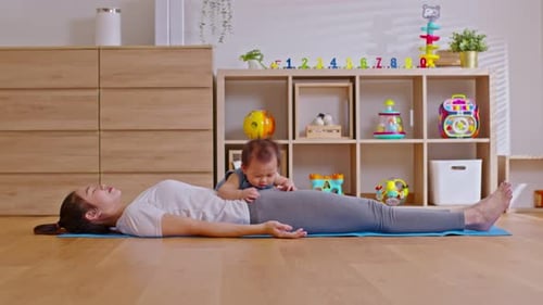Woman Lying on Yoga Mat with Baby
