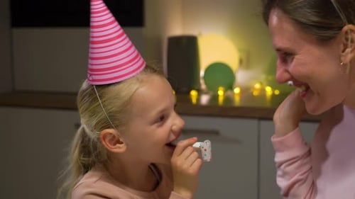 Happy Child and Adult Celebrate Birthday With Noisemakers