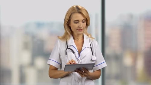 Woman Doctor Using Tablet in Hospital Office