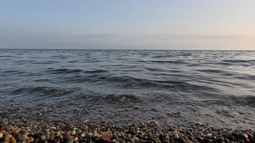 Sea Beach Horizon Olas marinas con aguas suaves y espumosas que lavan guijarros multicolores en una playa durante