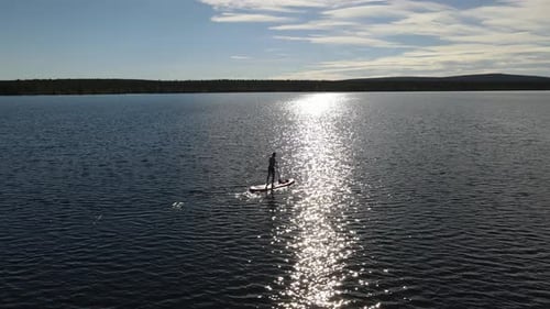 A man on the stand up by the lake