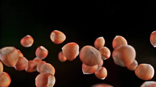 Super slow motion of rotating hazelnuts up to the air. Filmed on high speed cinema camera