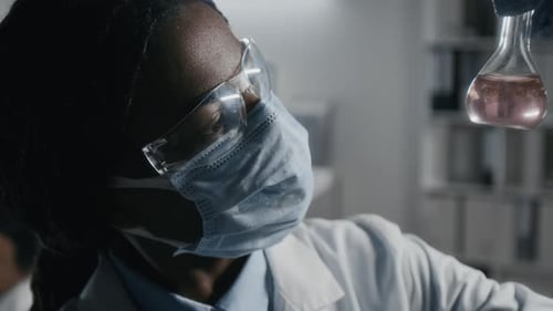 Scientist Inspecting Liquid Sample in Laboratory Setting